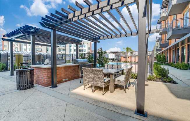 A patio with a table and chairs under a pergola.