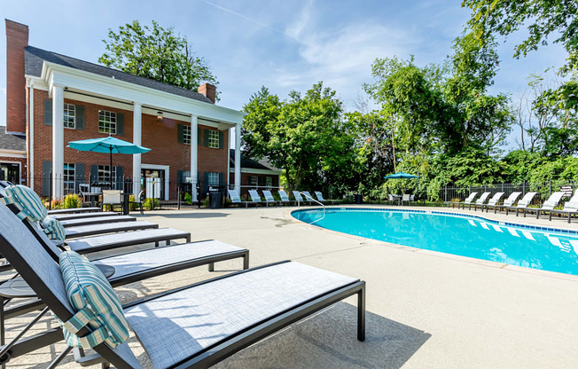 lounge chairs around a pool outside Littlestone Apartments clubhouse