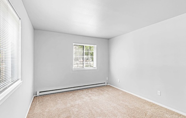 A room with a window and carpeted floor.