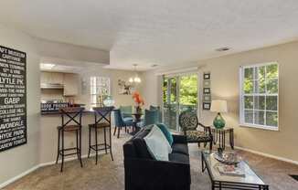 the living room and kitchen of an apartment with a couch and a table