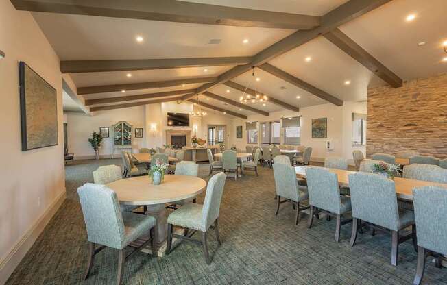 A dining room with a table surrounded by chairs.