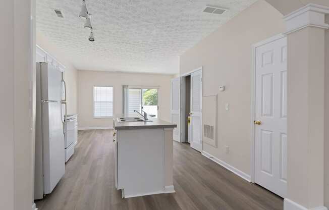 an empty kitchen with a sink and a refrigerator