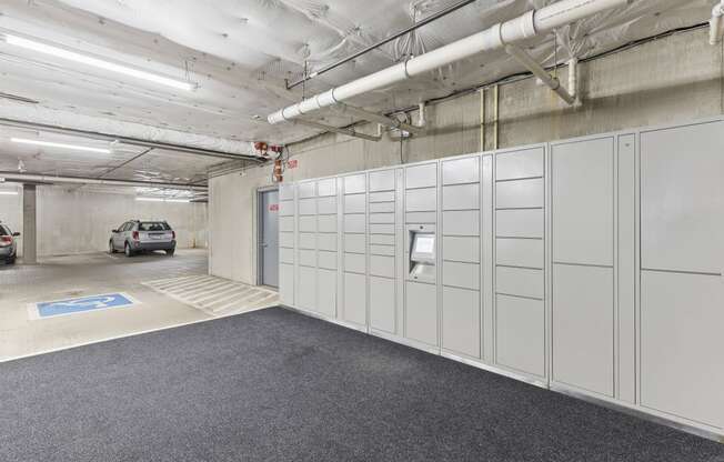 a row of package receiving lockers in the resident parking garage at Guinevere Apartment Homes, Seattle, Washington 98103