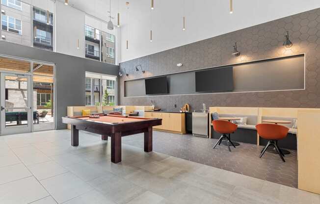 a game room with a pool table  and a kitchen