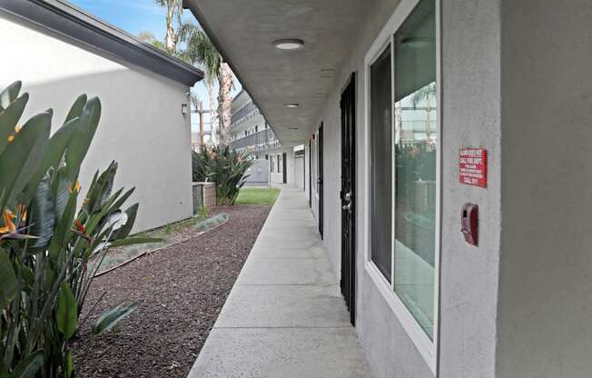 A long hallway with a red fire alarm on the wall.