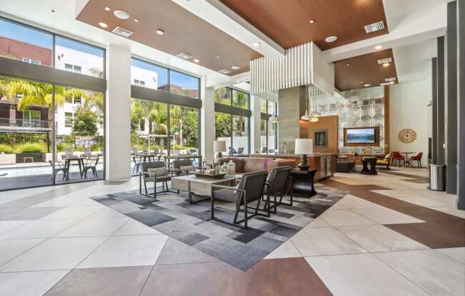 a large lobby with a table and chairs and large windows