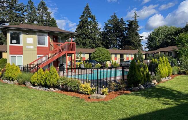 a yard with a pool and a house with a fence