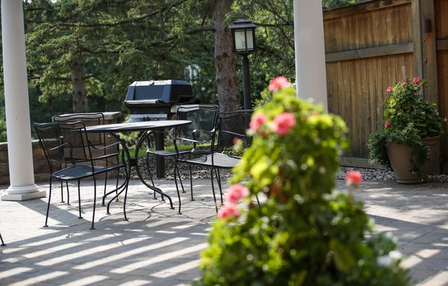 a patio with tables and chairs and an outdoor grill