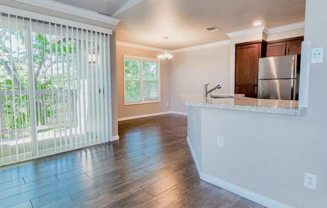 living room with wood-tpyr flooring looking into kitchen