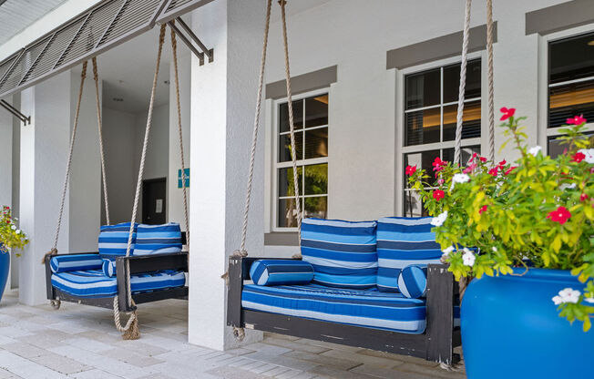 two love seat size swings with blue cushions outside the clubhouse