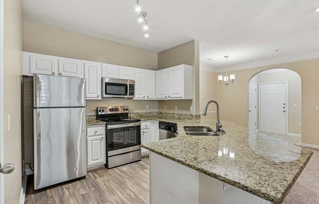 A kitchen with granite countertops and stainless steel appliances.