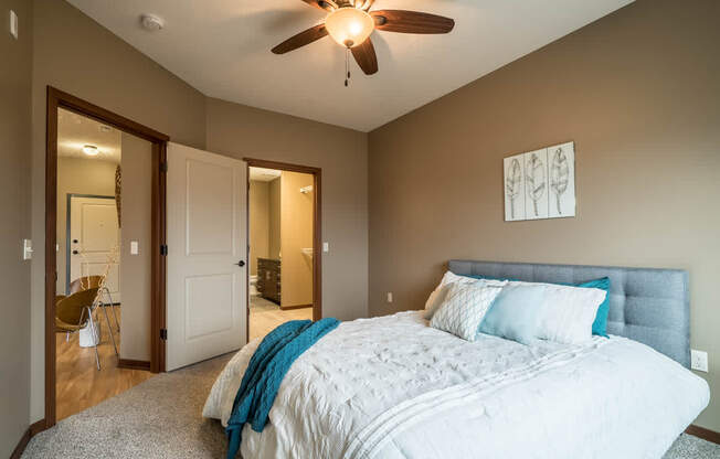 A bedroom with a large bed and a ceiling fan.