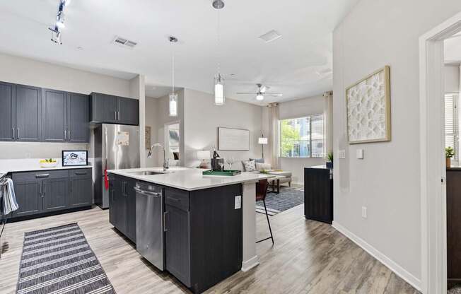 A modern kitchen with dark grey cabinets and a white countertop.