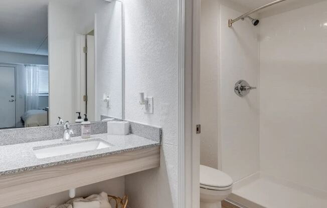 a bathroom with a sink and a shower and a mirror at The Teale Navy Yard, North Charleston