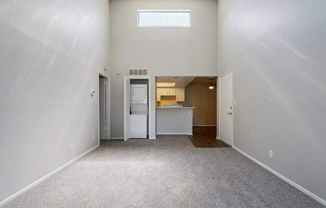 A white room with a fridge and a window.