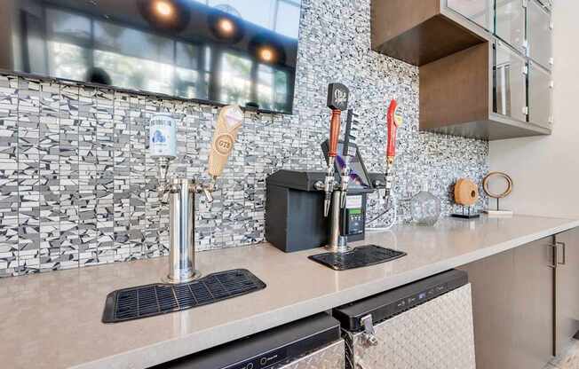 A kitchen with a black and white tiled backsplash and a black dishwasher.