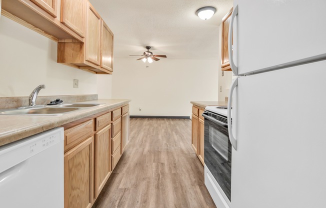 A kitchen with wooden cabinets and a white refrigerator.
