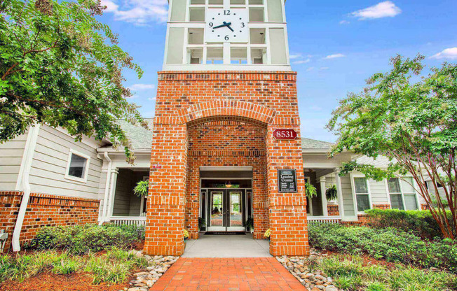 Entrance to leasing center at Seasons at Umstead apartments in Raleigh with clock tower and brick walls