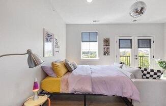 A bedroom with a bed, a lamp, and a poster on the wall.