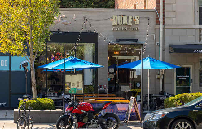 a motorcycle parked in front of a dukes counter on a city street
