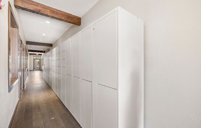 a long row of white cabinets in a hallway with wood floors at Lakeline East Apartments, Cedar Park, 78613