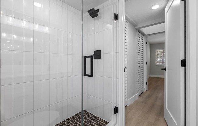 A white tiled bathroom with a walk-in shower.