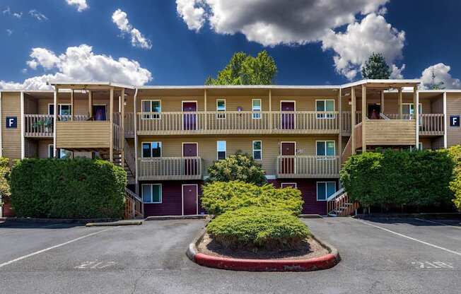 A large apartment complex with a parking lot in front.