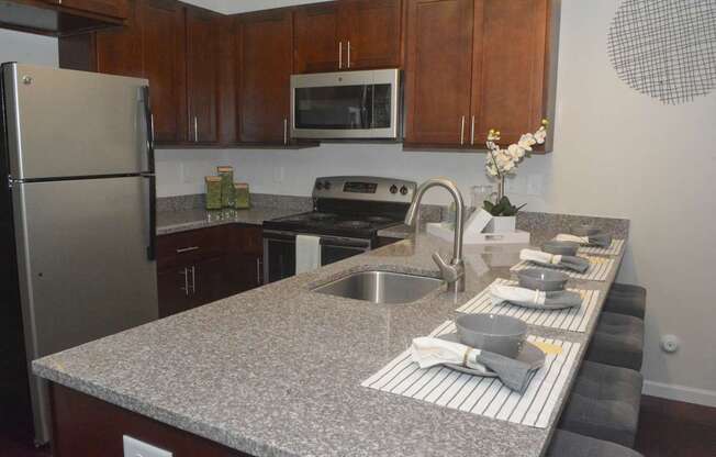 A kitchen with a granite countertop and stainless steel appliances.