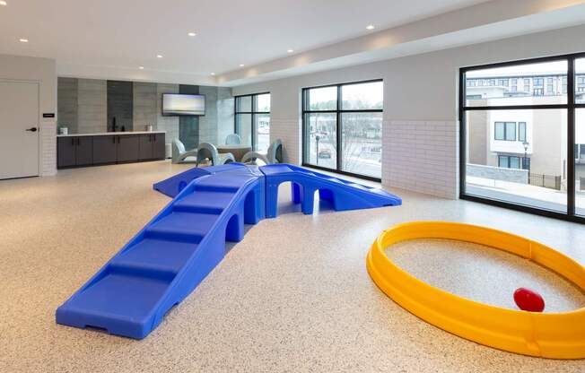 a childrens play room with a yellow tub and blue benches