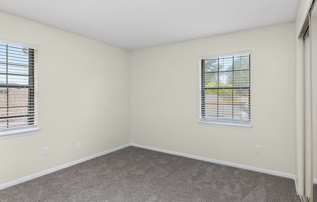 Gold carpeted bedroom interior at The Arbor Apartments in Blue Springs, Missouri