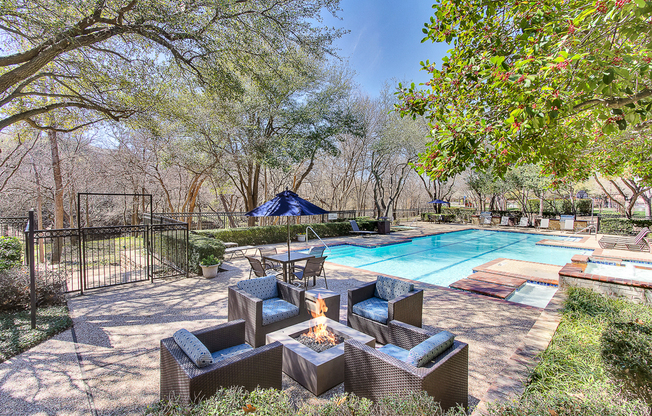 Stunning, tree-lined swimming pool and hot tub with fire pit, tanning deck and lounge seating