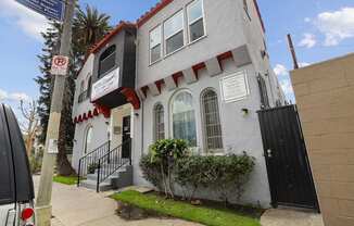 A white building with a red trim and a black door.