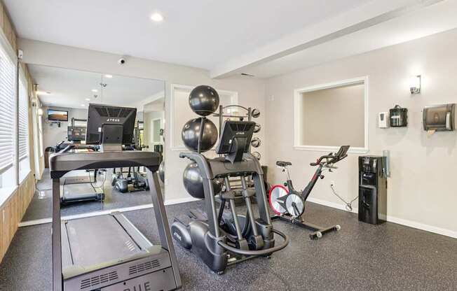 Fitness center with a treadmill, stationary bike, and other exercise equipment.