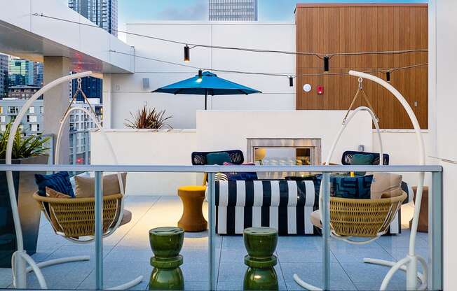 a view of a patio area with a couch and chairs and a fire place in the background