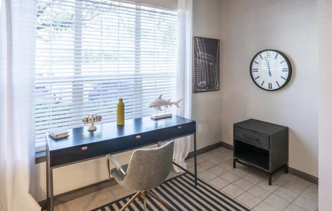 a home office with a desk and a clock on the wall
