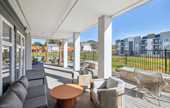 a living room with couches and a coffee table on a balcony