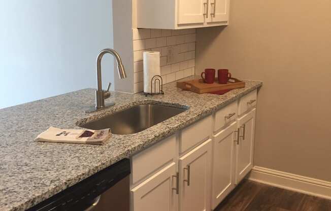 a kitchen with white cabinets and a granite counter top