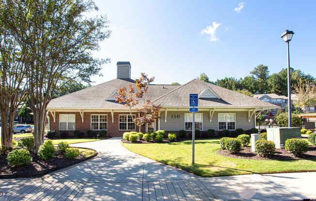 the front of a brick house with a lawn and trees