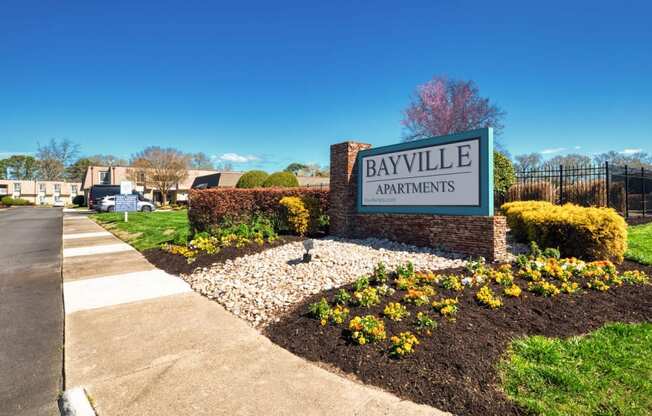 a sign apartments on the side of a sidewalk  at Bayville Apartments, Virginia, 23455