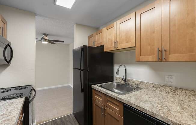 a kitchen with wood cabinets and granite-look countertops  at Park Edmonds Apartment Homes, Edmonds, WA
