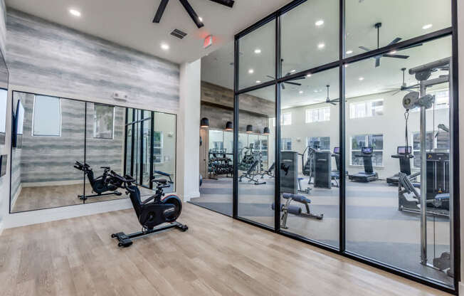 A gym with a wood floor and a glass wall.