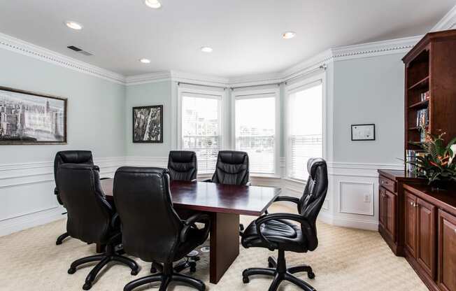 a conference room with a wooden table and black chairs