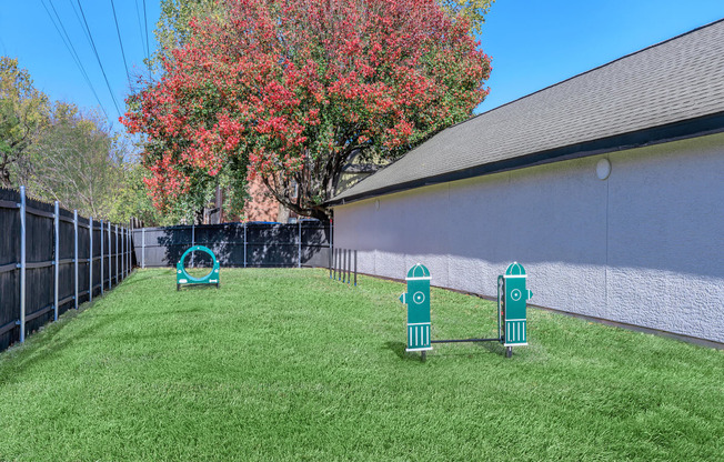 a backyard with a agility course and agility hoop