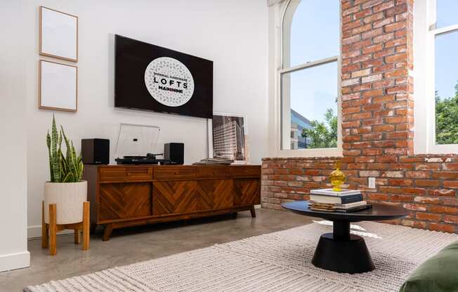 a living room with a brick wall and a large window