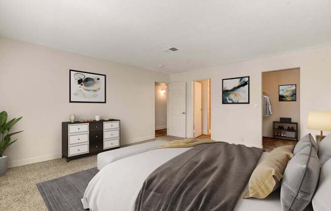 A bedroom with a bed, nightstands, and pictures on the wall.