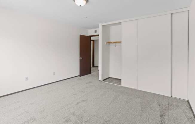 a bedroom with white walls and a carpeted floor