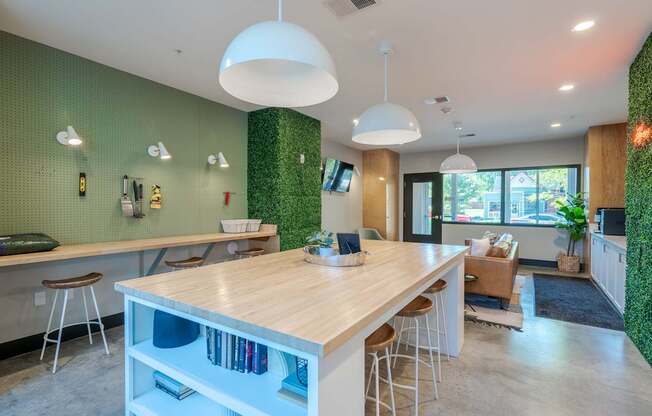 A modern kitchen with a wooden island and stools.