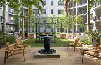 a courtyard with tables and chairs and a water fountain