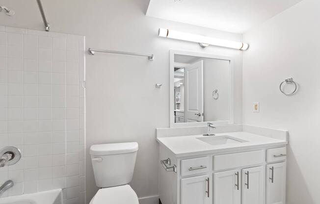 A white bathroom with a toilet, sink, and tub.
