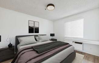 A bedroom with a large bed and a window with blinds.